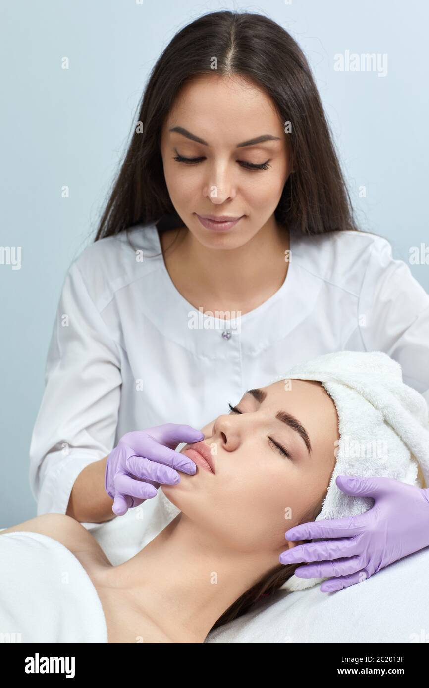 professional cosmetologist with beautiful woman patient in clinic. beautician consults of anti-aging treatments Stock Photo