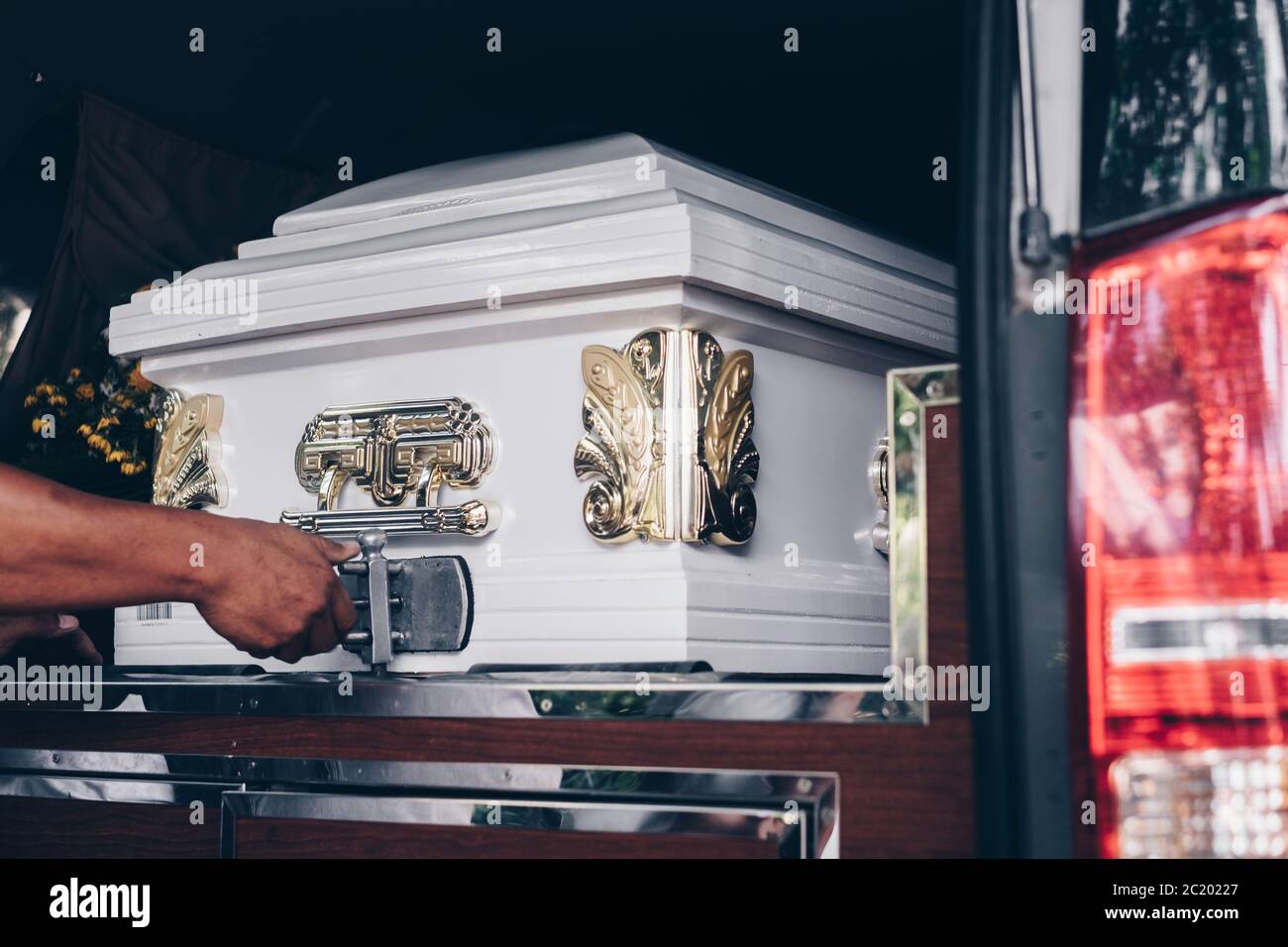 Close up of a casket loaded in a hearse or  funeral plan car or coach for the funeral procession. Selective focus. Stock Photo