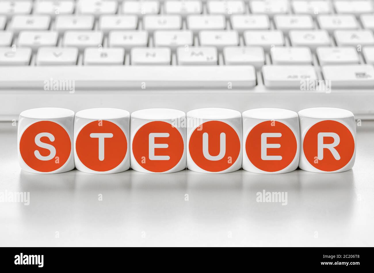 Letter dice in front of a keyboard - Tax - Steuer German Stock Photo