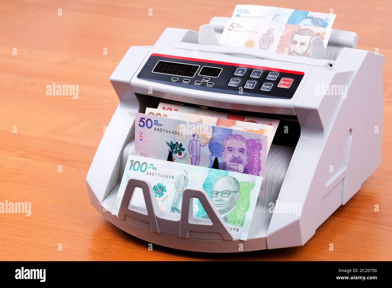 Colombian Pesos in a counting machine Stock Photo