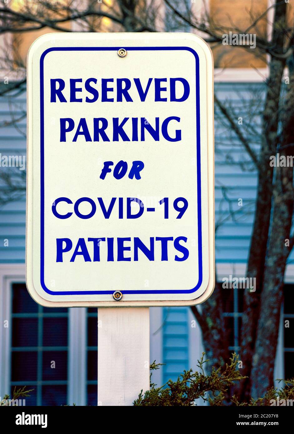 Parking sign indicates where COVID-19 patients should park at a medical testing and treatment facility parking lot. Stock Photo