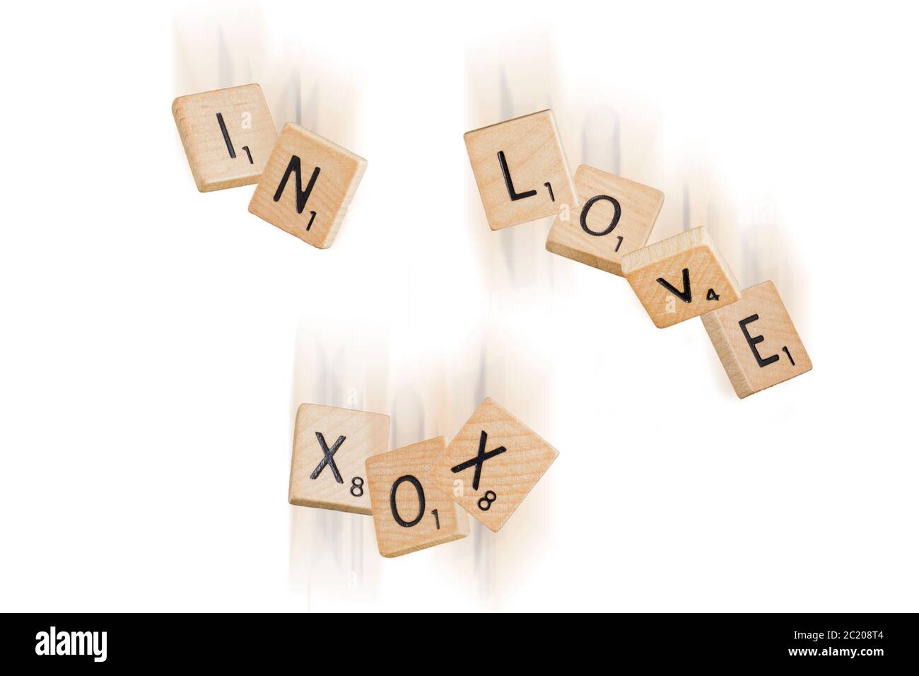 Falling scrabble pieces spelling the words 'in love XOX' Stock Photo