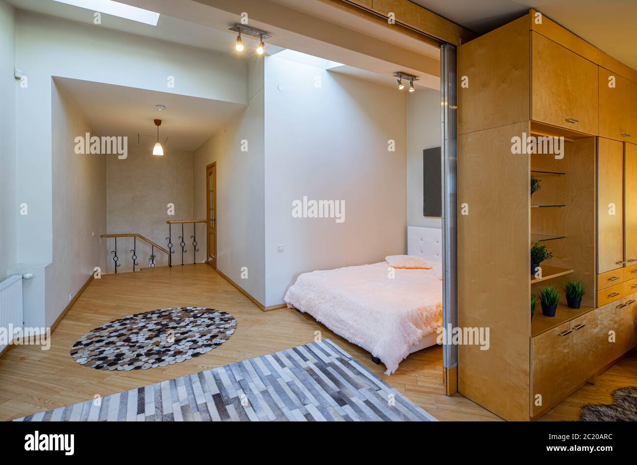 Modern interior of bedroom upstairs in luxury apartment. Cozy bed