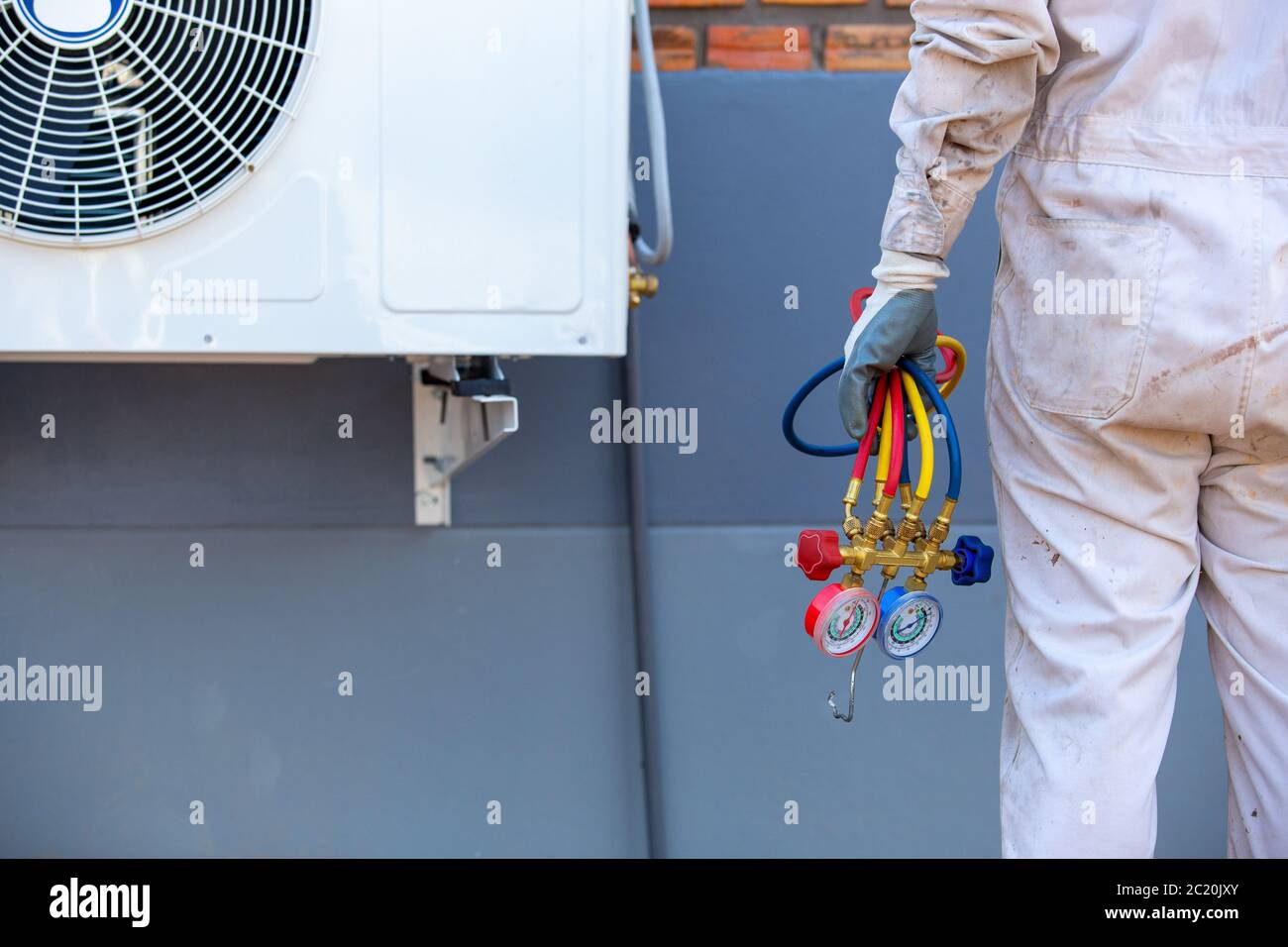 Air conditioning repairman carrying tools, gauges for measuring liquid