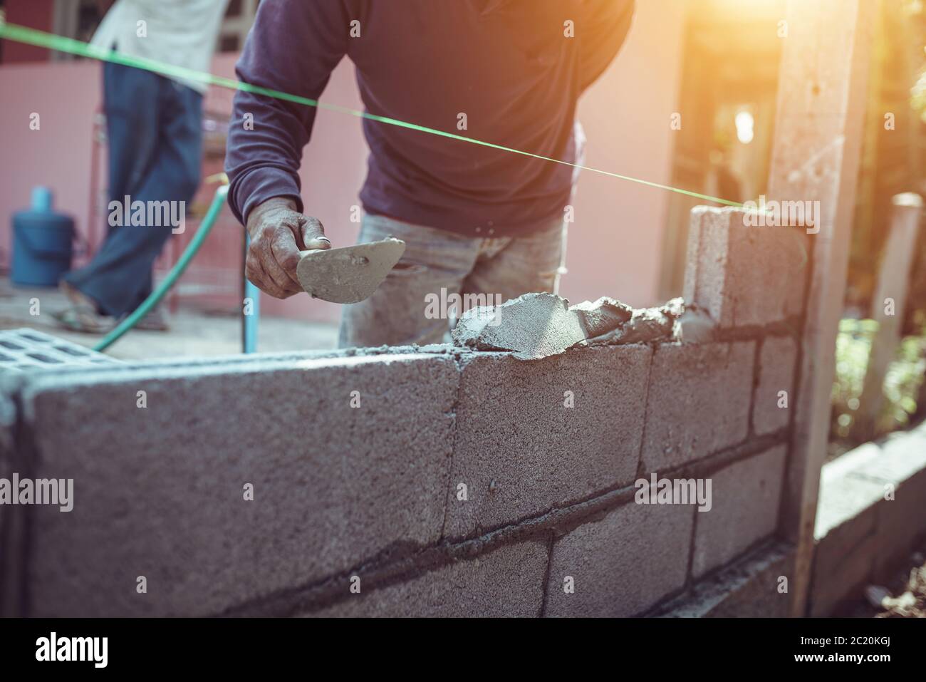 Bricklayer building a brick wall or wall construction. Stock Photo
