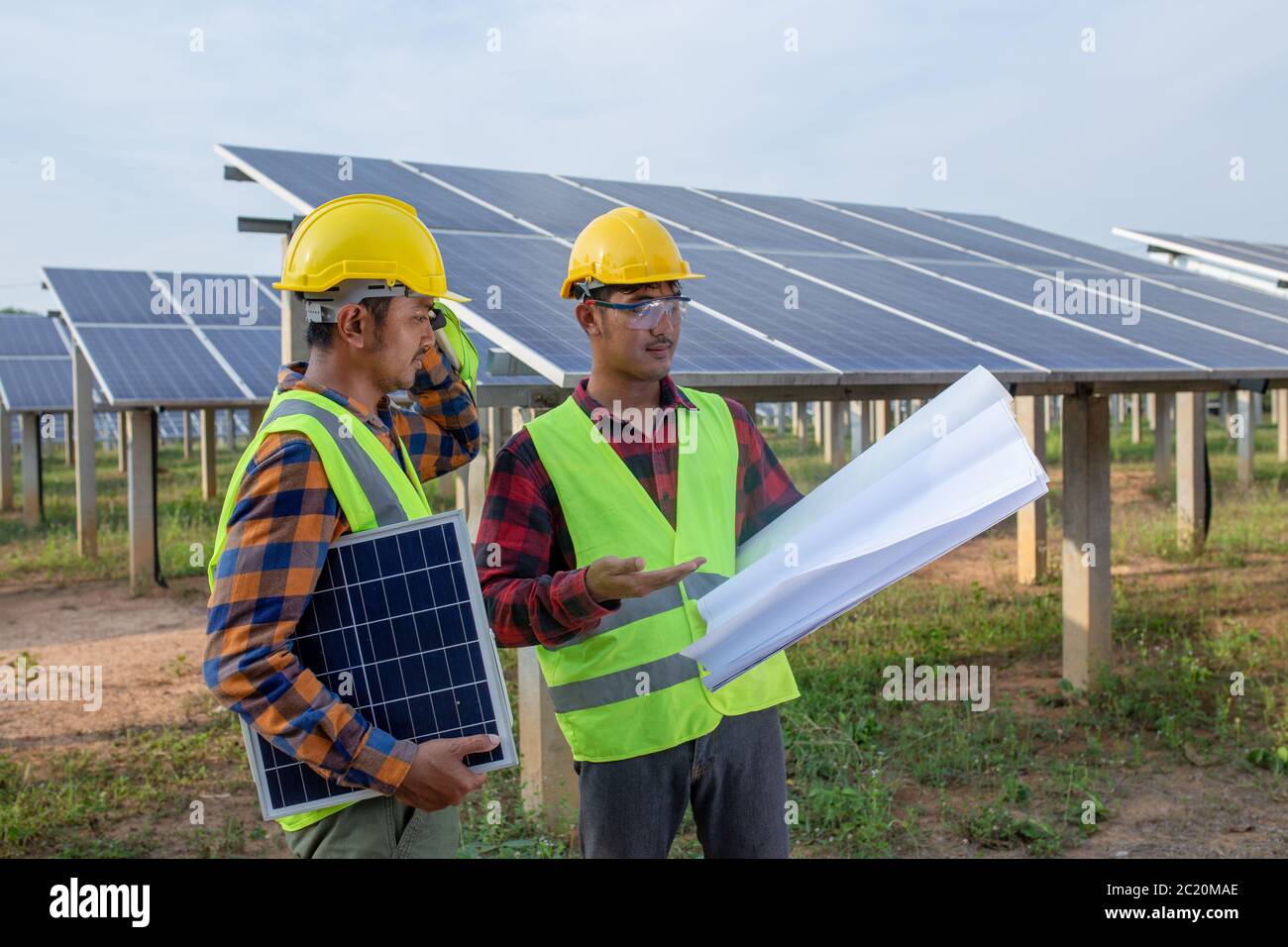 The engineering team is checking the blueprints for fixing or repairing solar panels and other analyses. Stock Photo