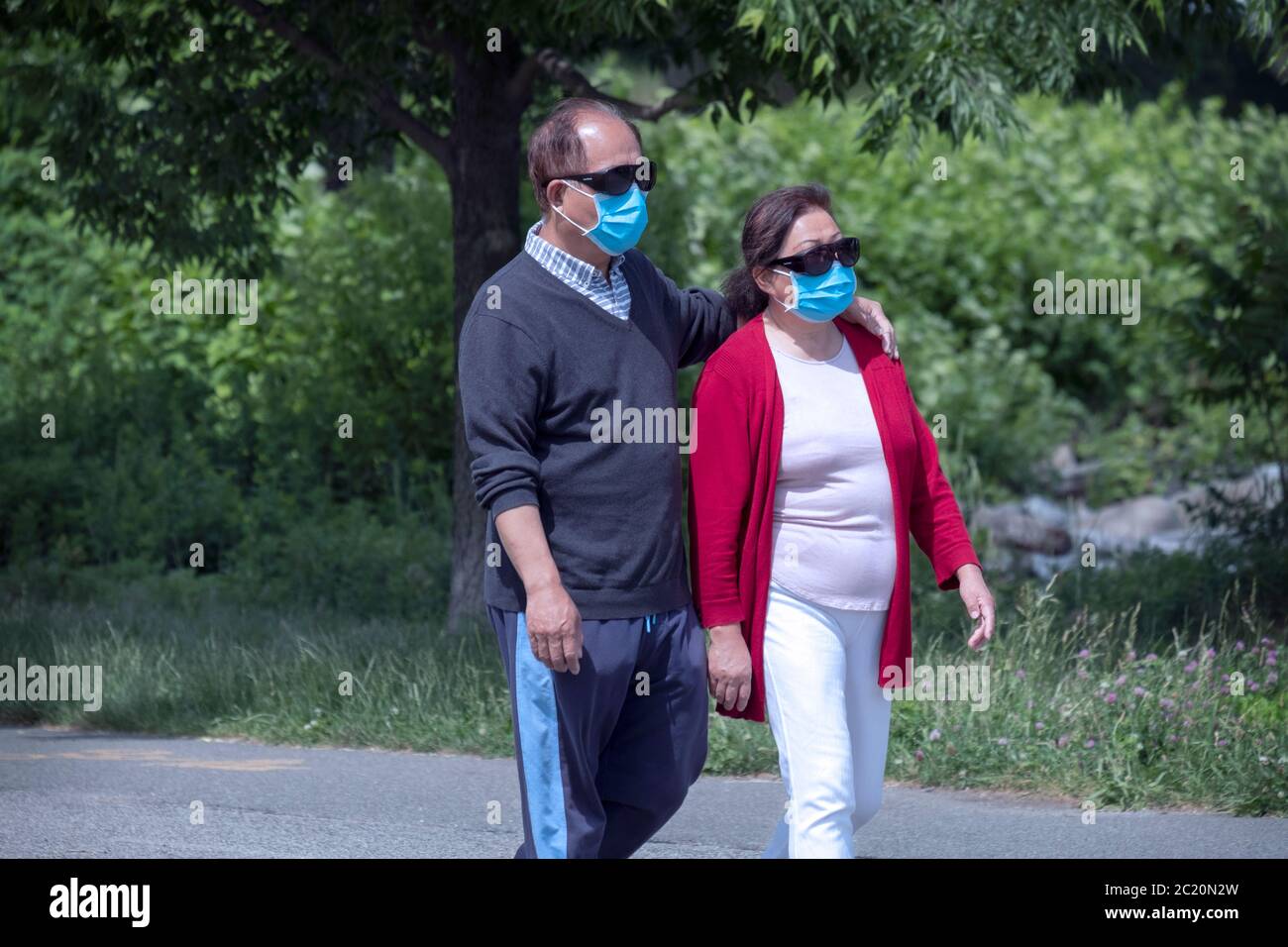 An Asian American couple, likely Korean Americans, on an exercise walk on a path in Little Bay Park in Whitestone, Queens, New York City. Stock Photo
