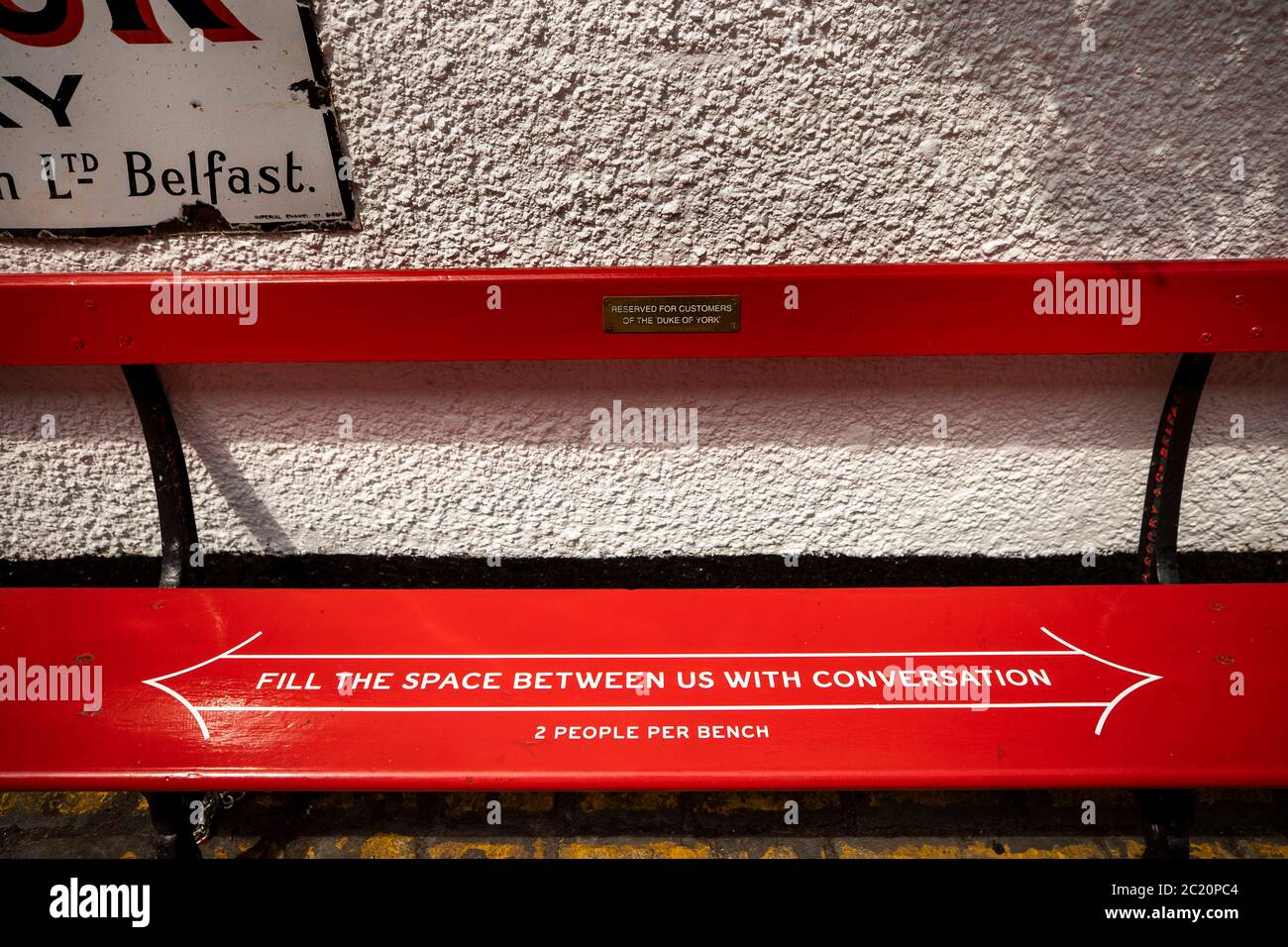 The Duke of York Bar, on Commercial Court in Belfast where the bar owner has taken a light hearted approach when bars are able to reopen after lockdown by putting quirky social distancing messages of the benches outside the bar. Stock Photo