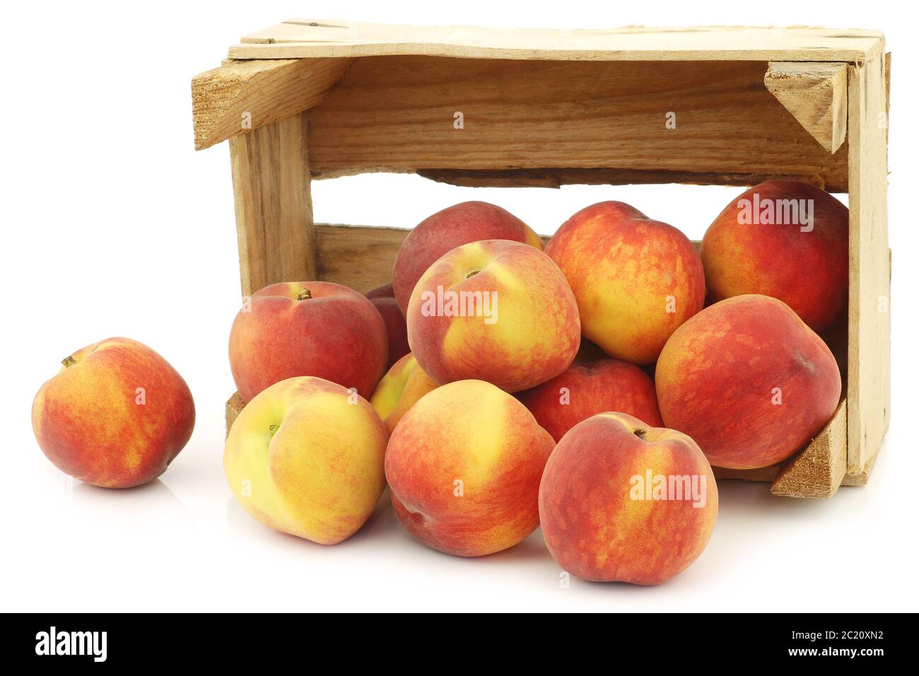Fresh peaches in a wooden crate on a white background Stock Photo