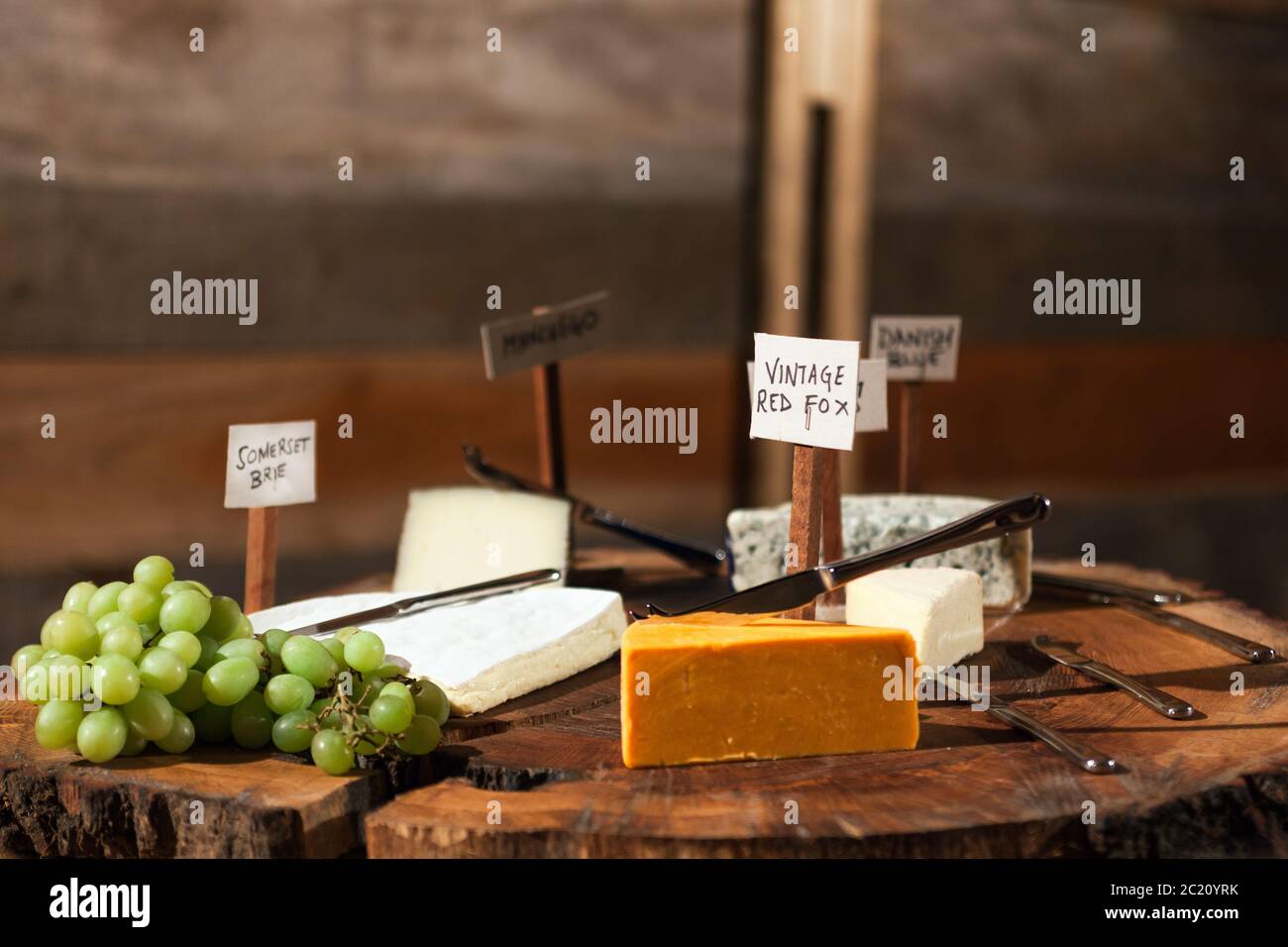 Rustic cheese board with a selection of labelled cheeses and cured