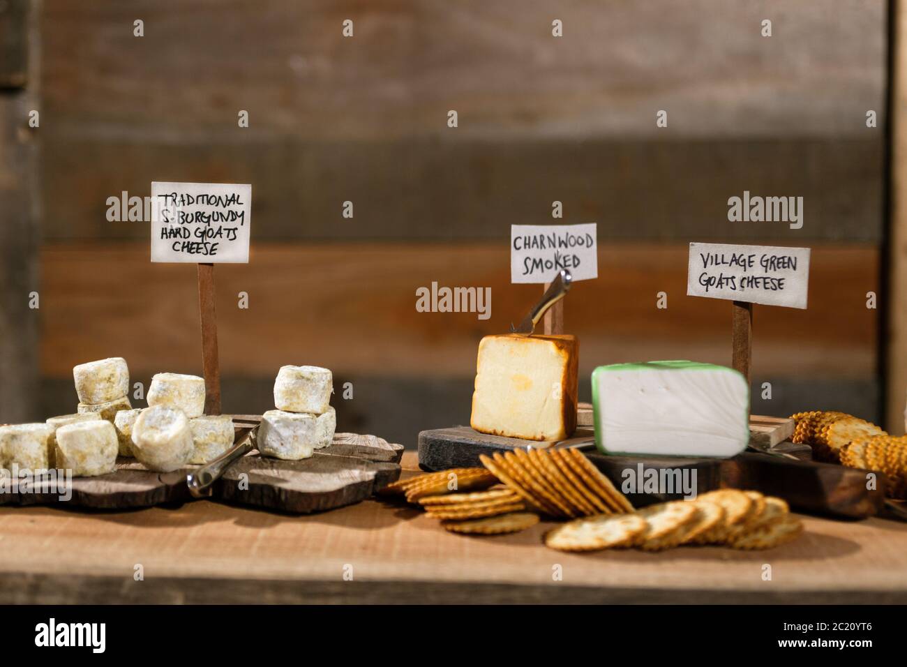 Rustic cheese board with a selection of labelled cheeses and cured