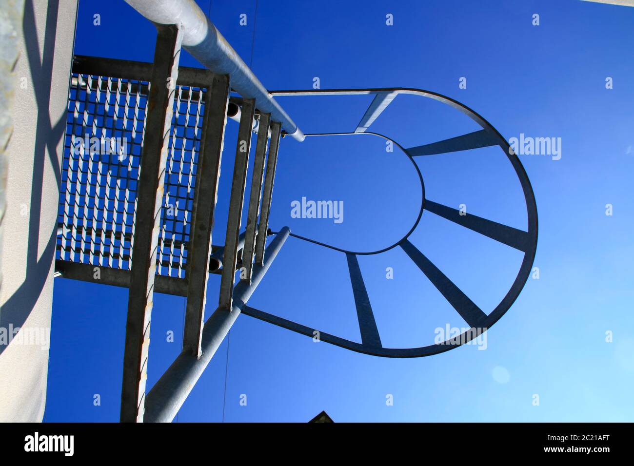 View from below of a ladder with safety bar. The look Symbolizes the ascent with certainty. Stock Photo