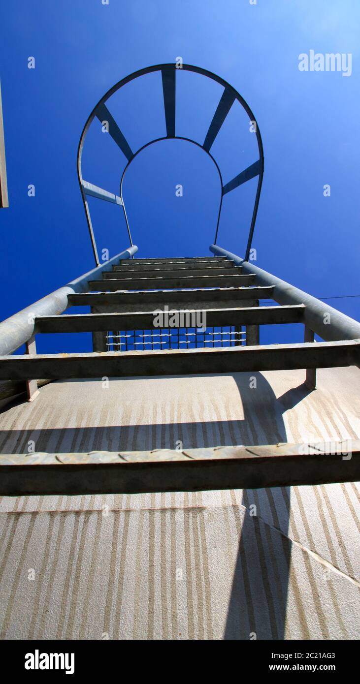 View from below of a ladder with safety bar. The look Symbolizes the ascent with certainty. Stock Photo