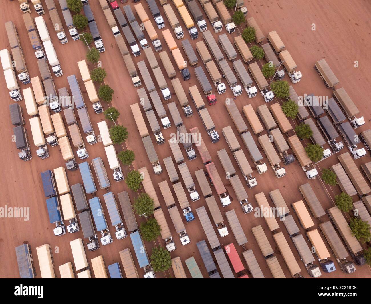 Drone aerial view top shot of row of trucks transporting soybeans in BR 163 road gas station garage on Amazon, Para, Brazil. Concept of transportation Stock Photo
