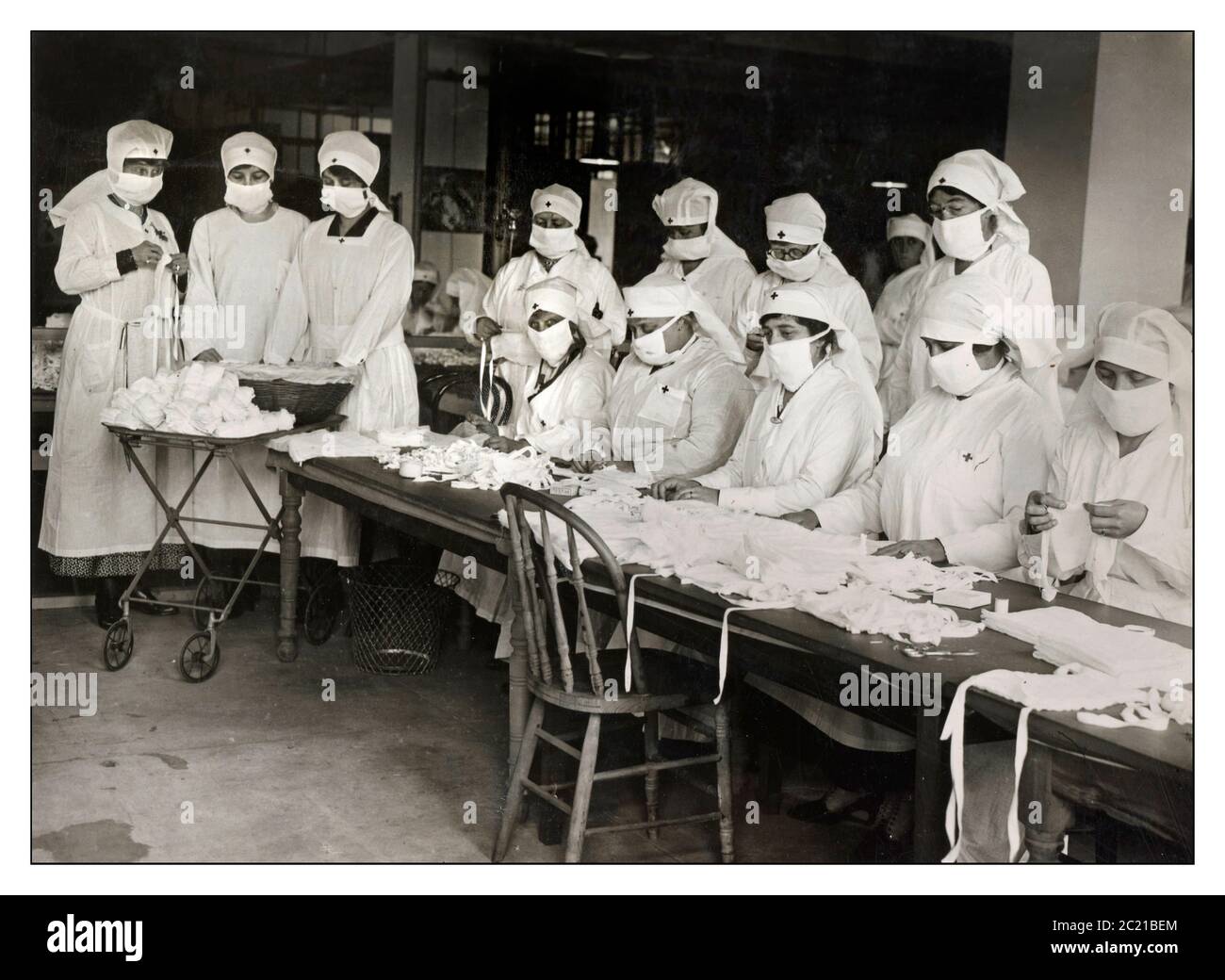 Mask Face Masks 1900s Spanish Flu mask Pandemic 1918 Red Cross volunteers making white (PPE) gauze face masks, which became mandatory in many public situations in the United States during the 1918 Spanish Influenza Pandemic Stock Photo