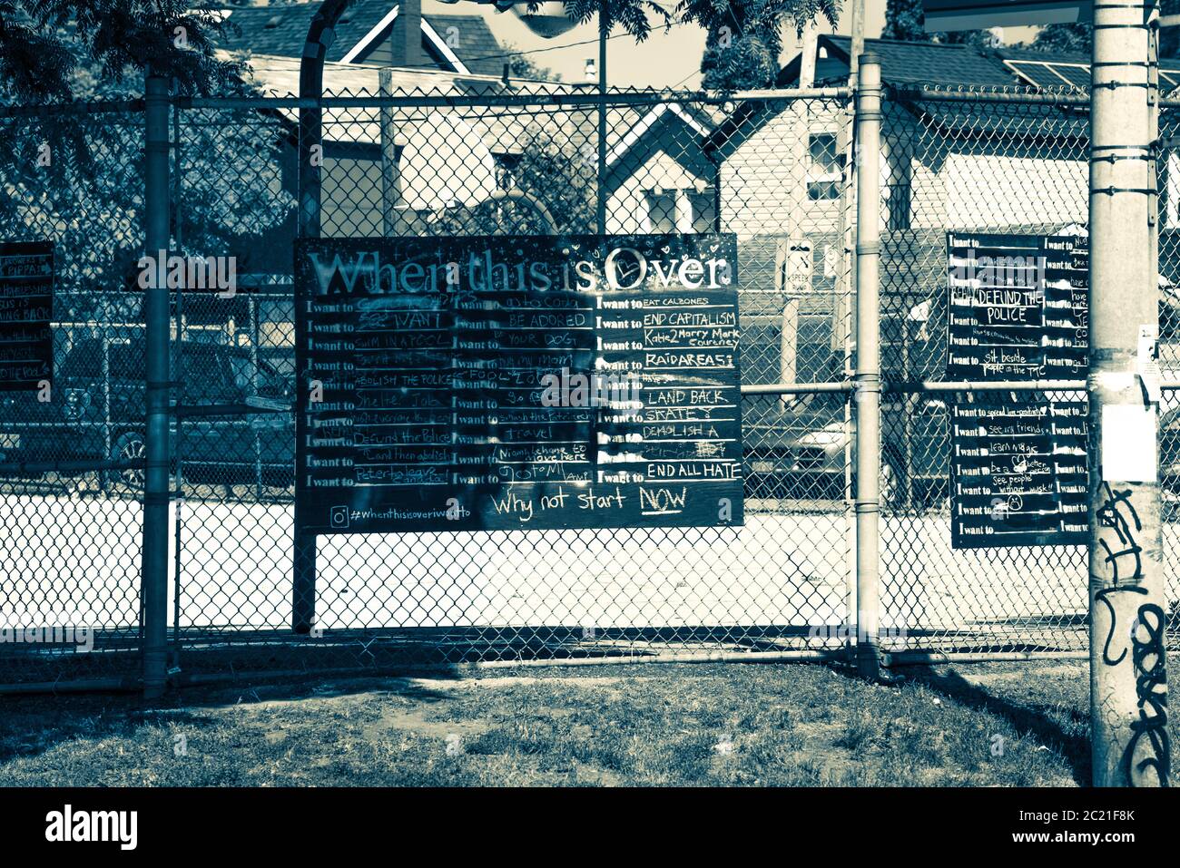 When This Is Over - a black and white photograph of an urban community blackboard with chalk written wishes of things to do once the pandemic is over. Stock Photo