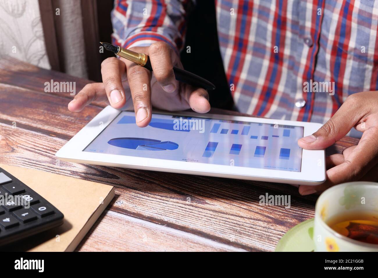 man's hand working on digital tablet at office desk, using self created ...