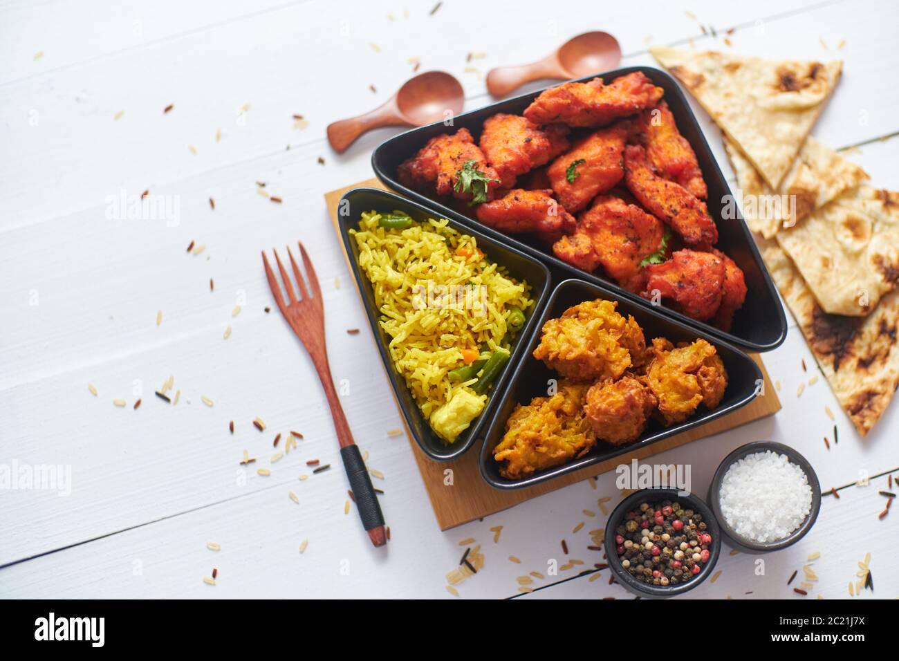 Spicy indian fried chicken served with curry vegetable rice, onion