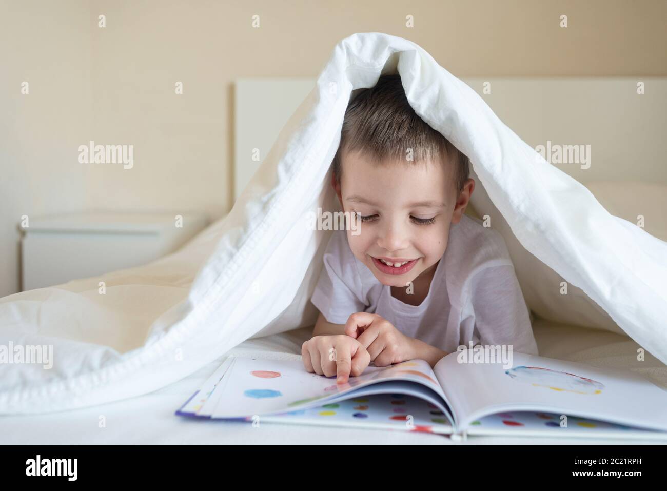 Little girl pointing and reading a book hires stock photography and