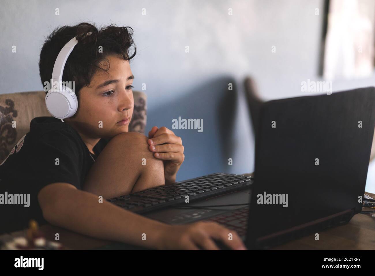 Boy doing his homework on laptop Stock Photo