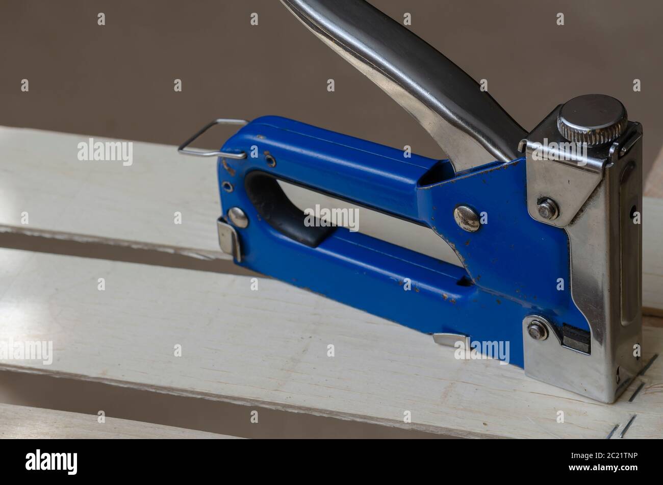 Industrial used stapler stands on a new wooden box. Production of eco