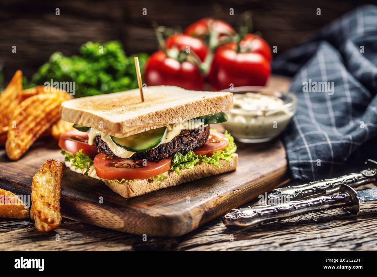 Minced beans vegan toast with lettuce, tomato and cucumber, potato wedges and mayonaise Stock Photo