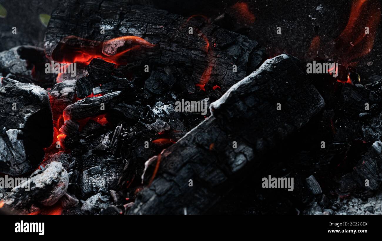 Black coals with fire and sparks in the grill. Preparation for cooking kebabs. Stock Photo