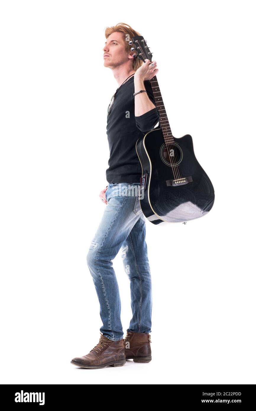 Confident young rocker man musician holding guitar looking up for ...