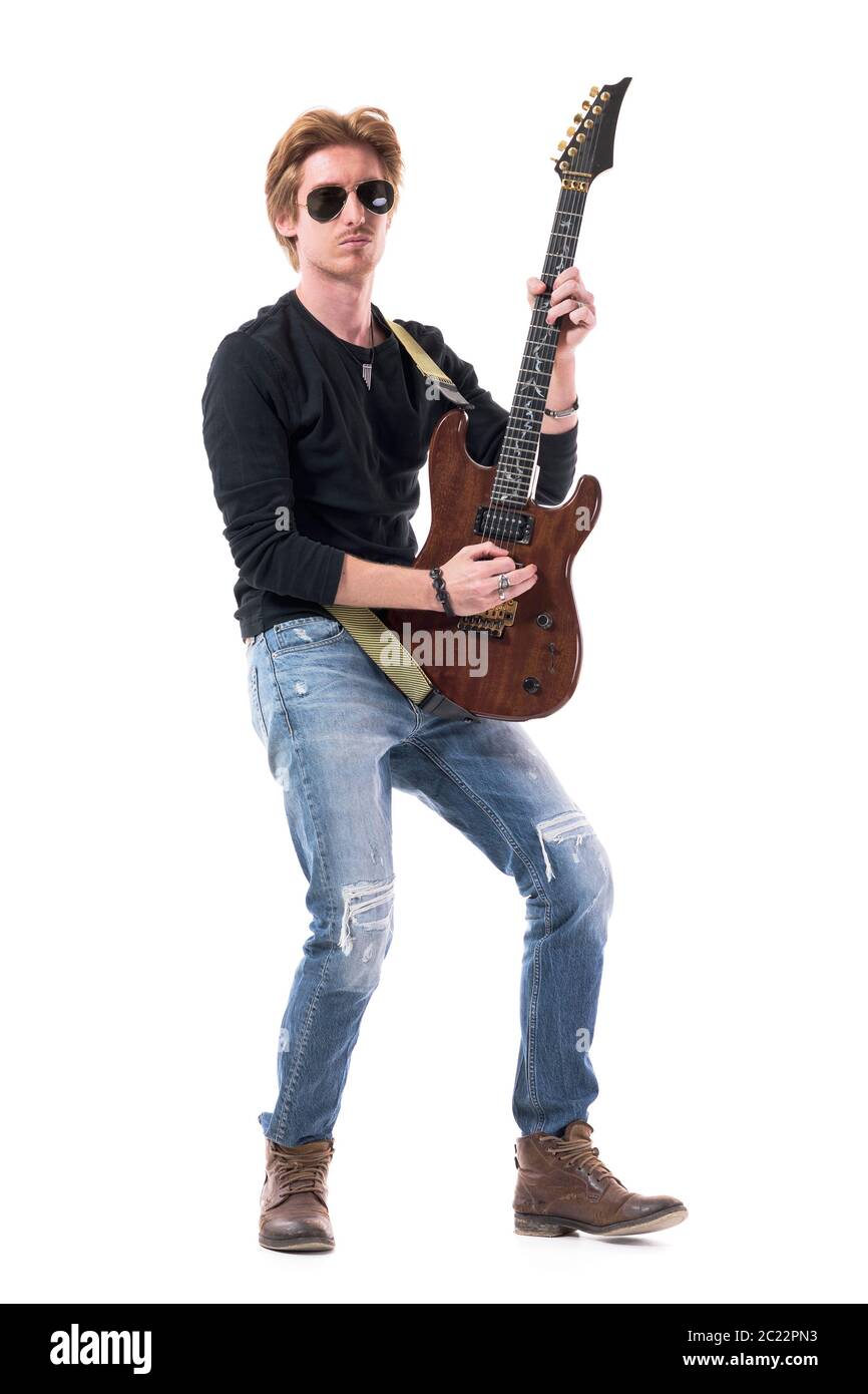Serious confident rocker guitarist playing electric guitar with
