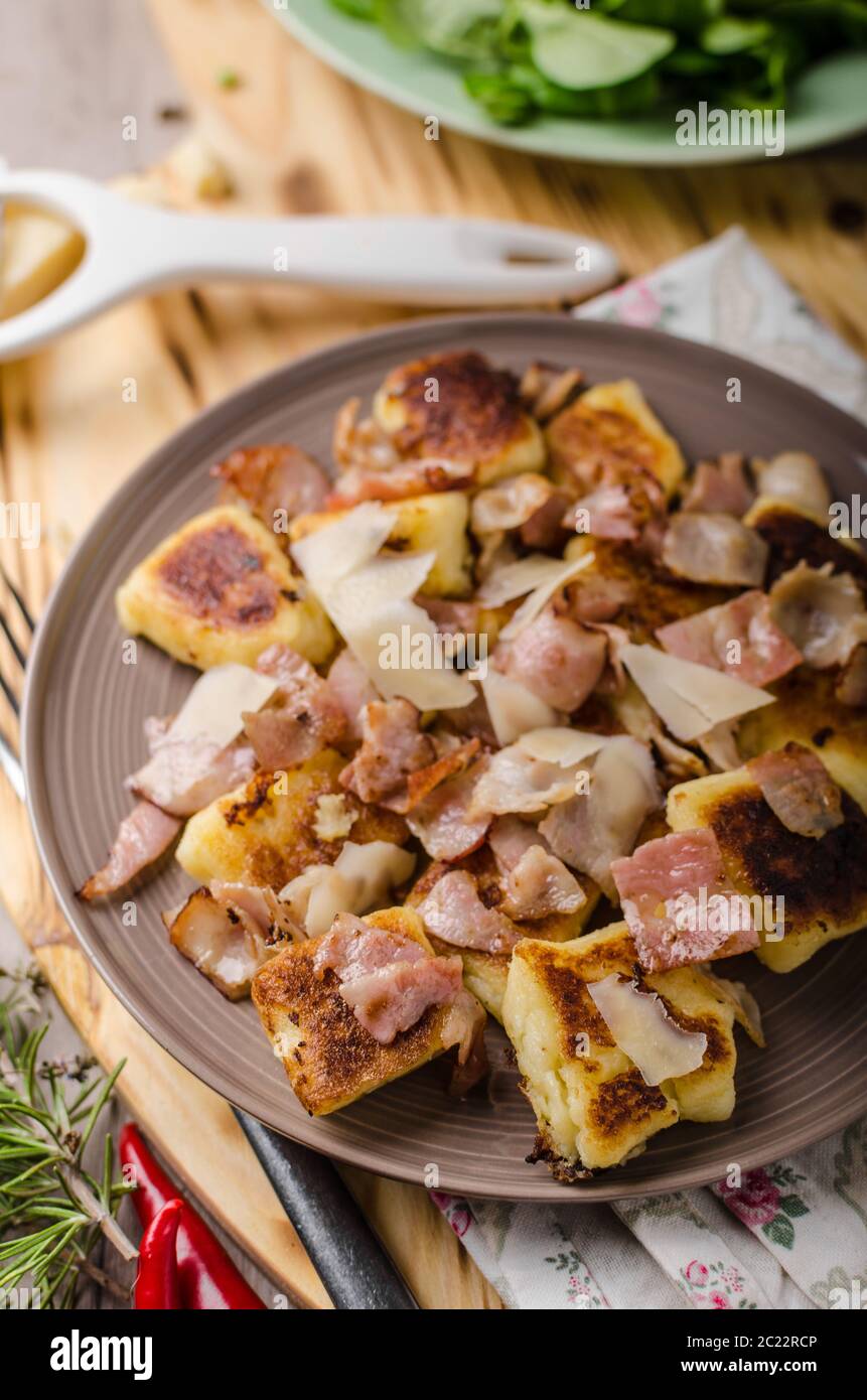 Home baked gnocchi with bacon and parmesan, fresh salad behind Stock