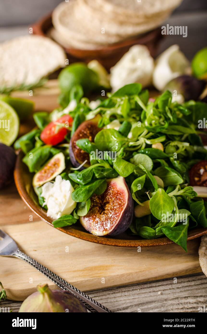 Delicious figs salad with tomatoes, lamb lettuce, cheese and homemade naan bread Stock Photo