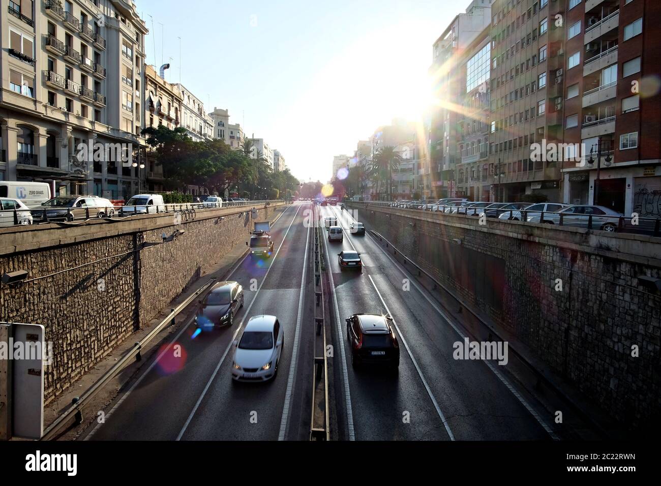 Traffic in the morning light with flare in Valencia, Spain Stock Photo