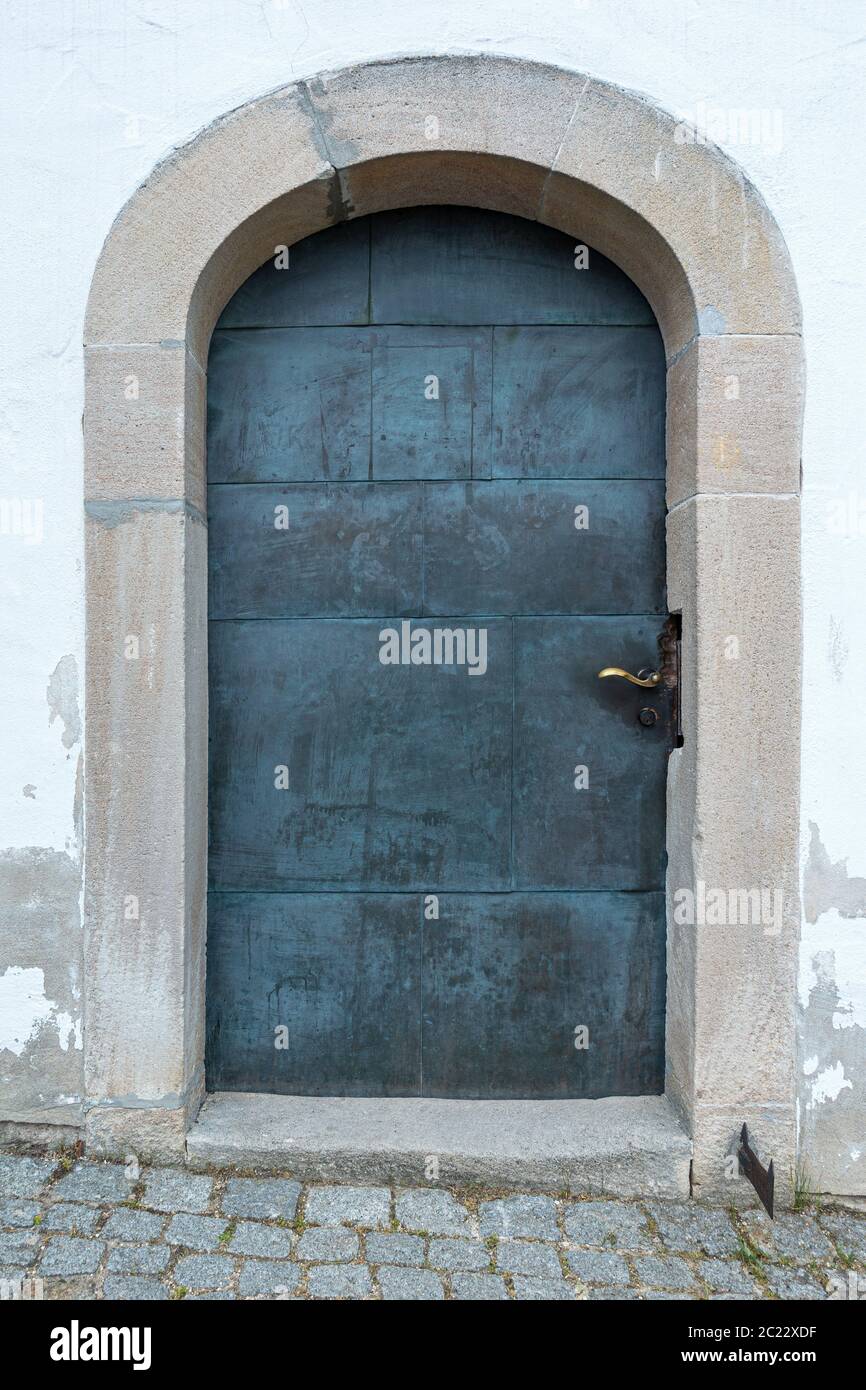 Old circular metal door with stone arch, taken at a church Stock Photo