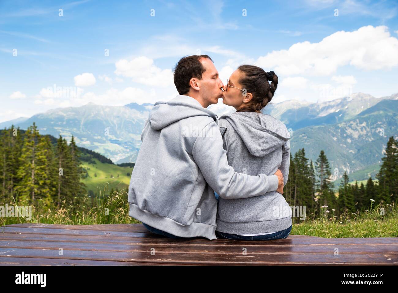 Couple Sitting On Bench Enjoying Panoramic Mountain View Stock Photo ...