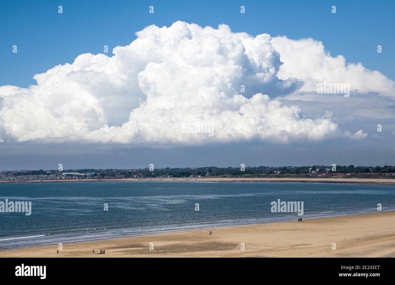 The south wales coast at Ogmore by sea  with, behind it, an enormous cumulonimbus cloud towering into the sky over Porthcawl to the west. South Wales Stock Photo