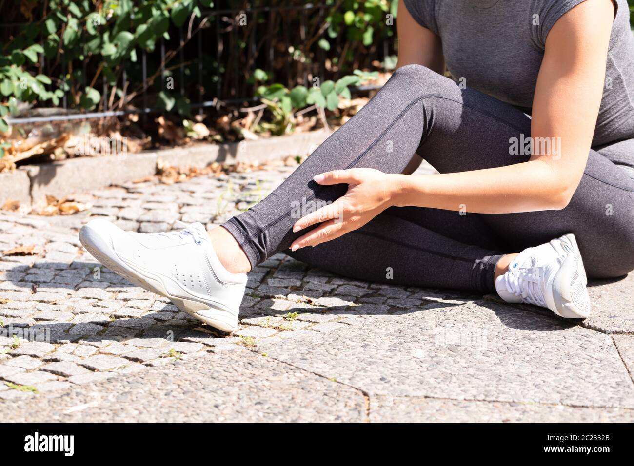 Closeup Of A Female Runner Suffering From Pain In Calf Muscle Stock