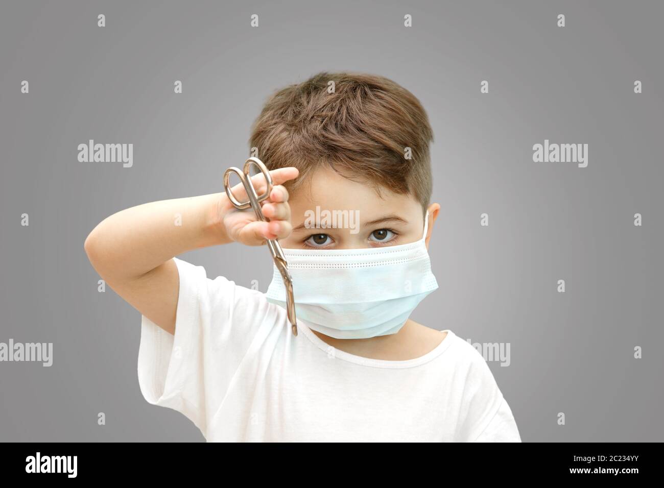 little Caucasian boy in a medical mask on an isolated background ...