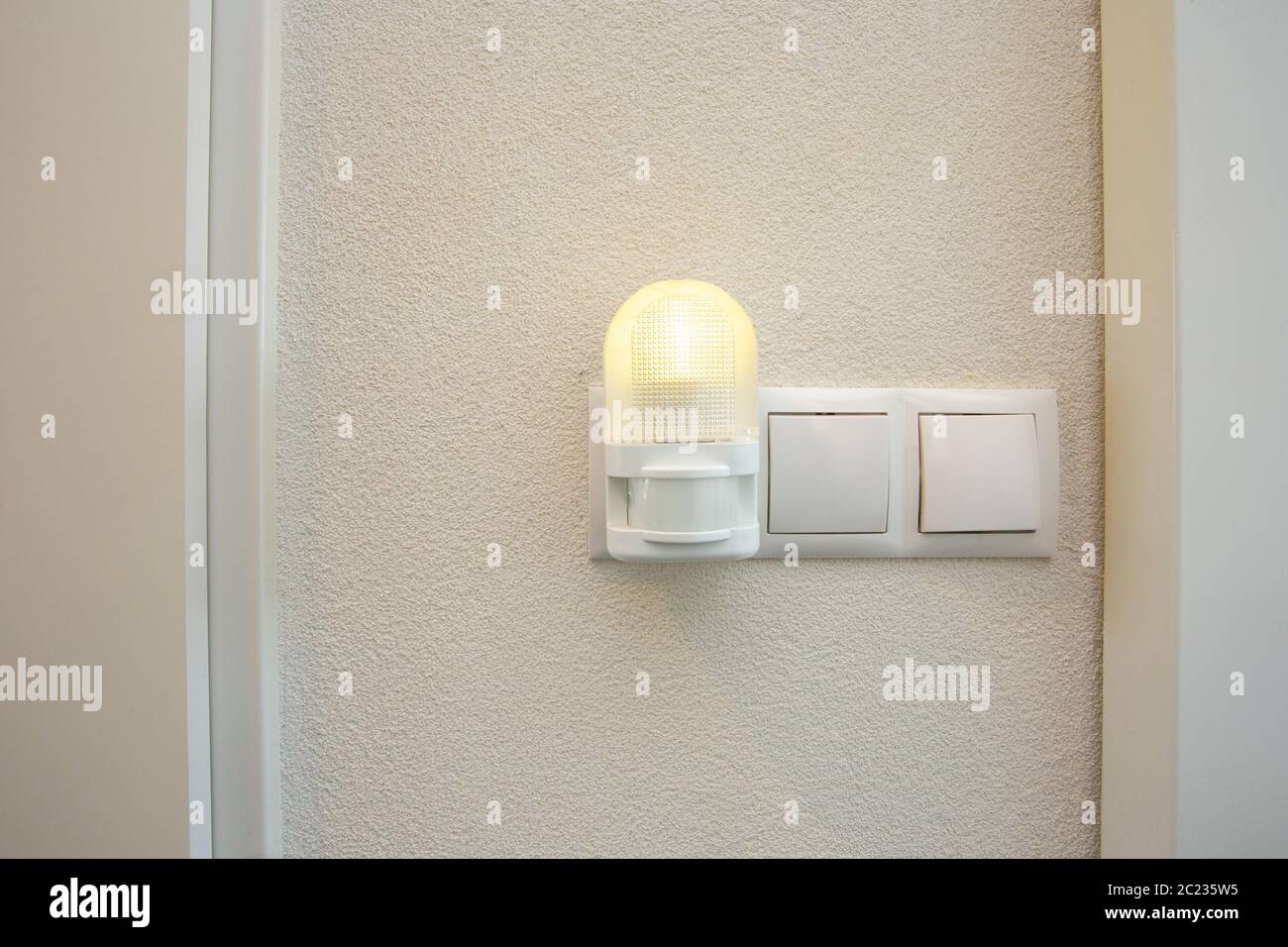 Night light plug in white socket on white wall turns on automatically