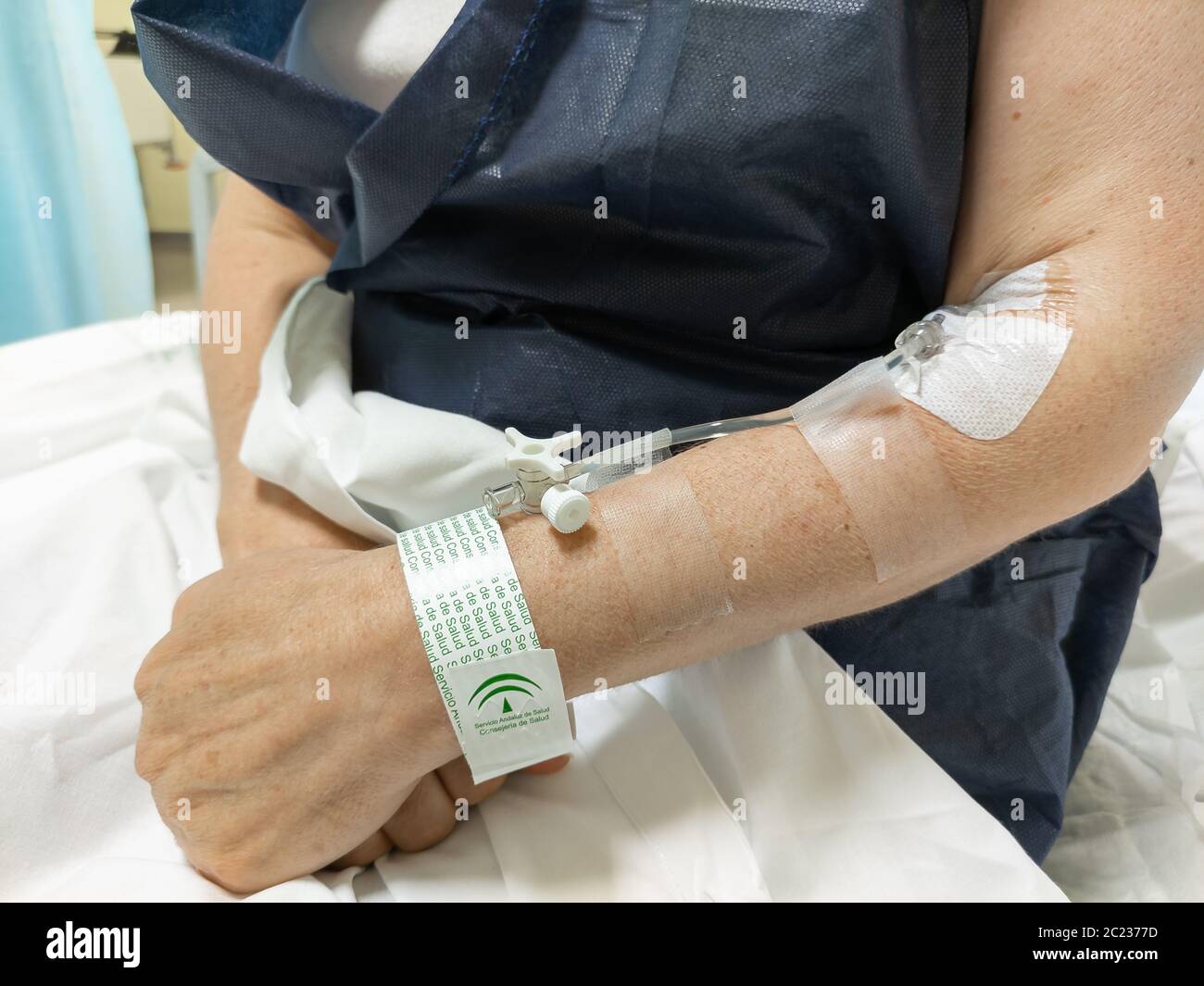 Huelva, Spain - June 16, 2020: Hands of female patient with a Peripheral venous catheter in the vein inside hospital Juan Ramon Jimenez in Huelva, Spa Stock Photo