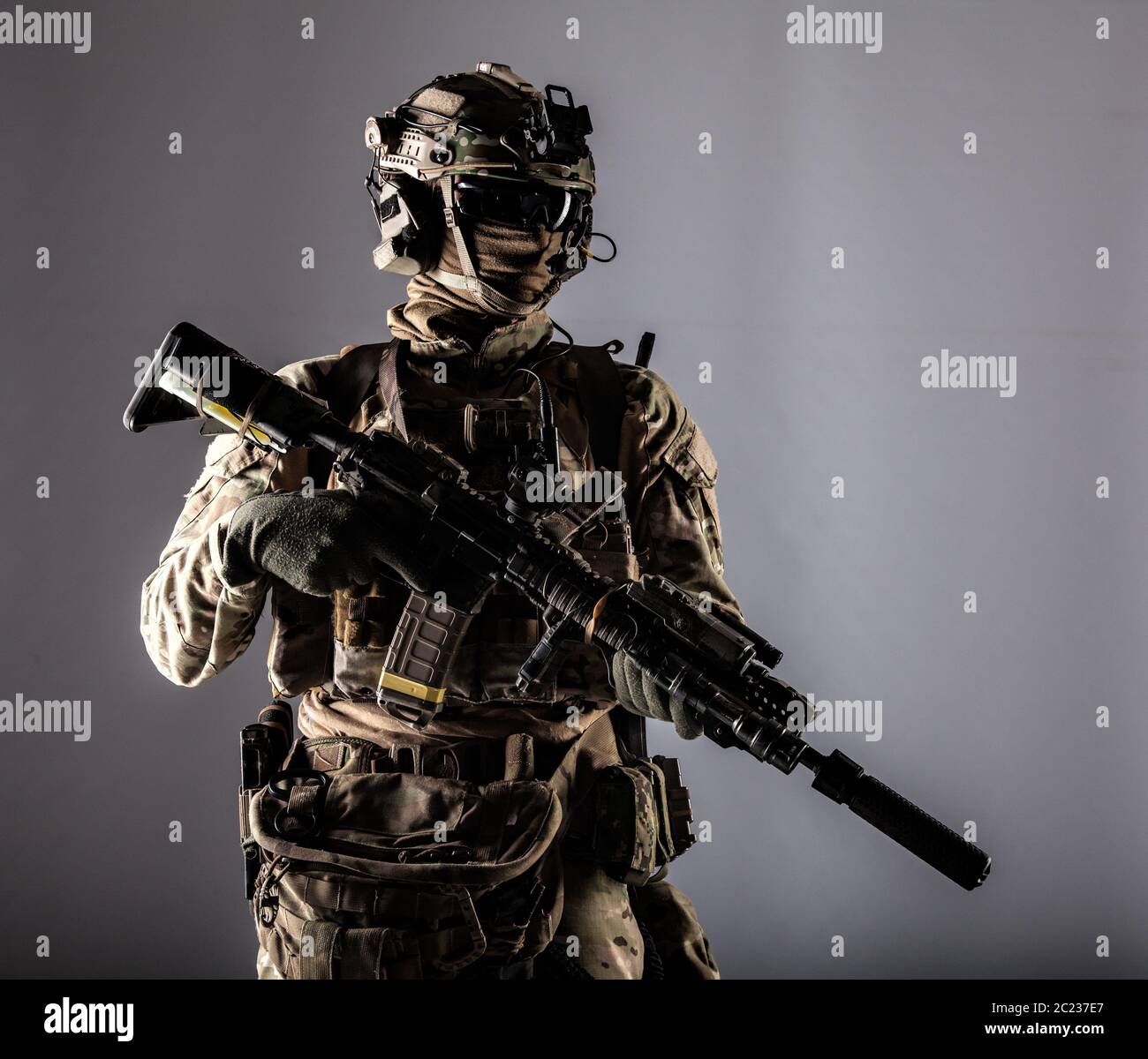 Special forces fighter in battle uniform and helmet with radio headset, face  mask and ballistic glasses, standing with equipped laser sight and silenc  Stock Photo - Alamy