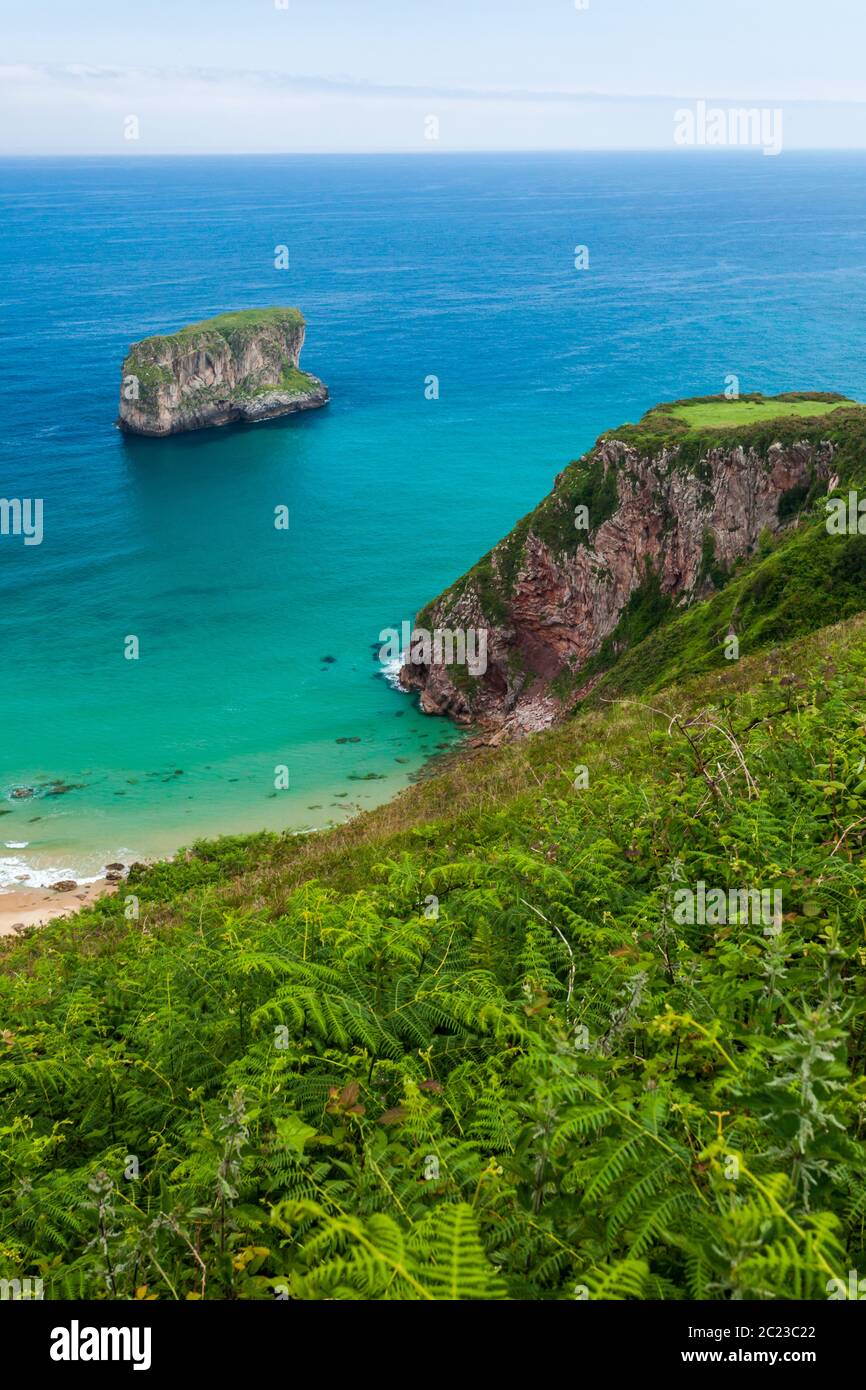 Ballota beach with the islet Castro, Llanes, Asturias , Spain Stock