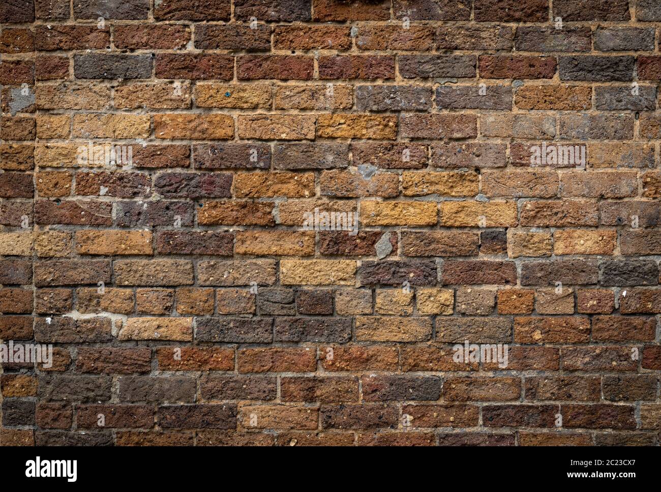 Mixed rustic brick background, rough texture backdrop in shades of brown and yellow ochre, creative copy space, horizontal aspect Stock Photo