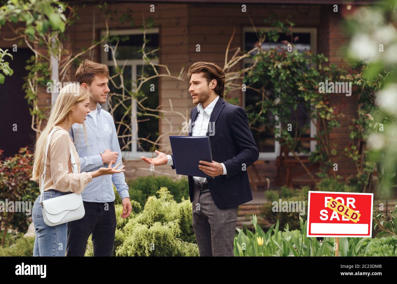 Unhappy customers arguing with property manager about house purchase outdoors, empty space Stock Photo