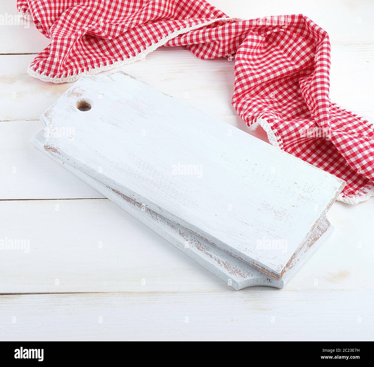 rectangular empty wooden cutting boards and red towel, white table Stock Photo