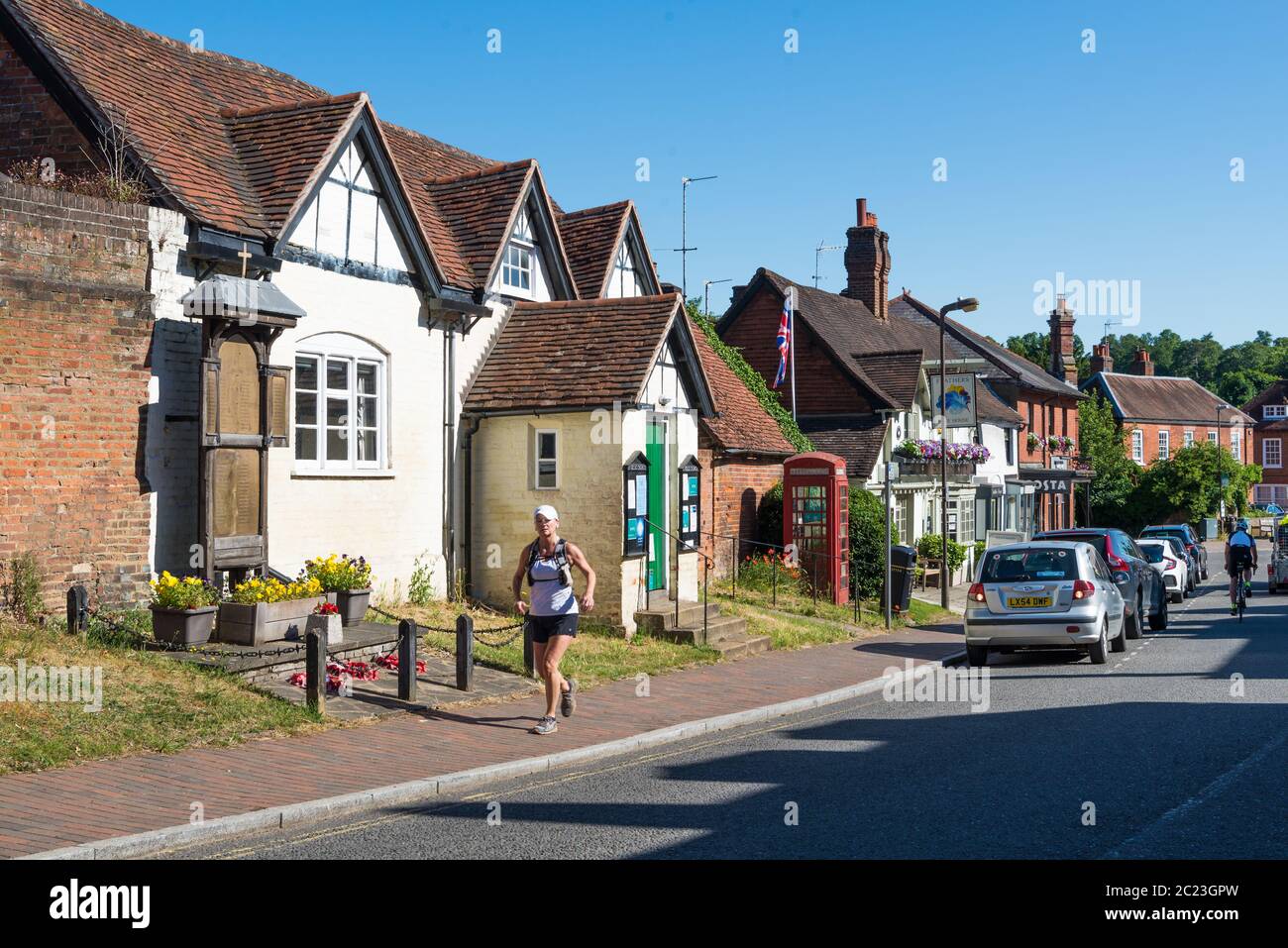 Woman jogger passes St. Giles church reading room in High Street