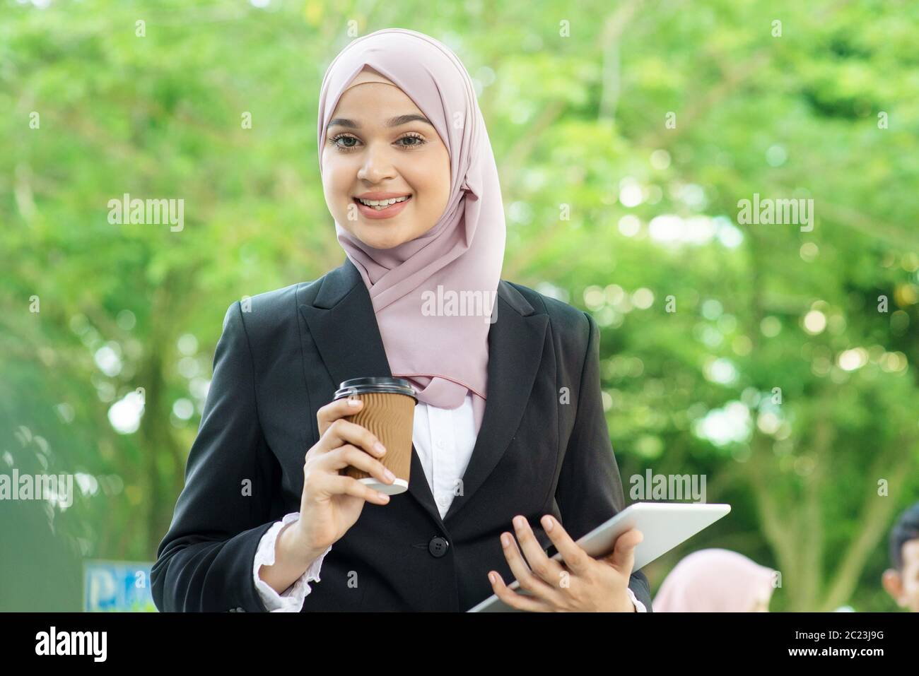 Muslim business woman drinking coffee while going to work in morning. Stock Photo
