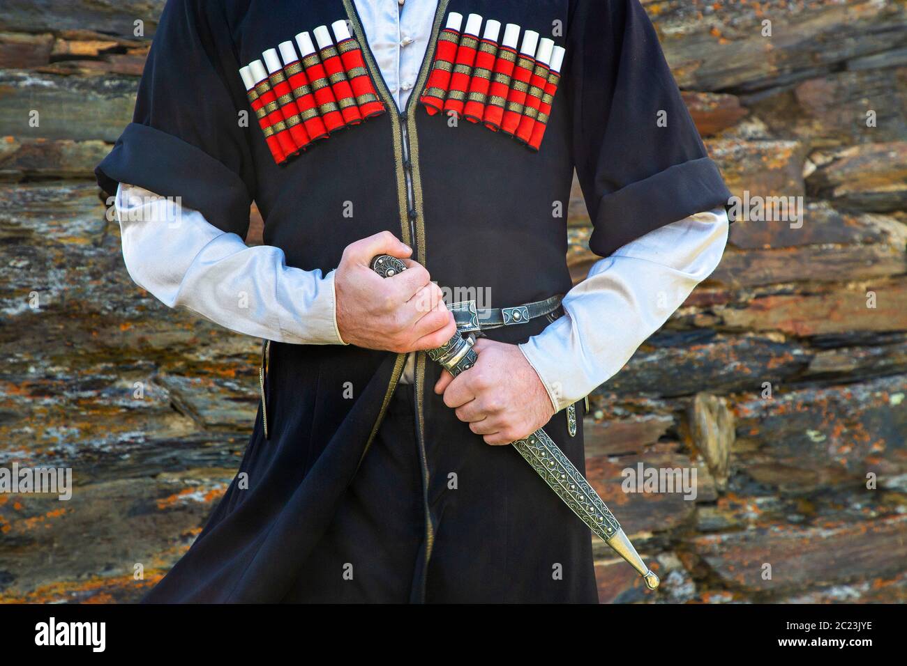 Georgian man in traditional clothes holding the dagger, Caucasus Mountains, Georgia Stock Photo