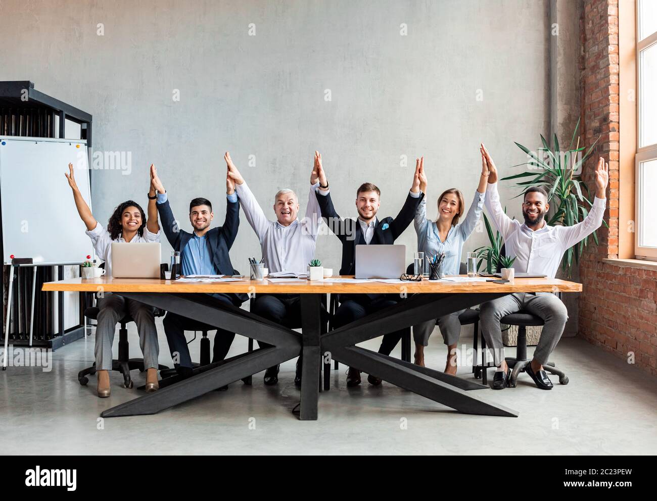 Colleagues Giving High-Five Celebrating Business Success Standing In Office  Stock Photo by ©Milkos 381522740