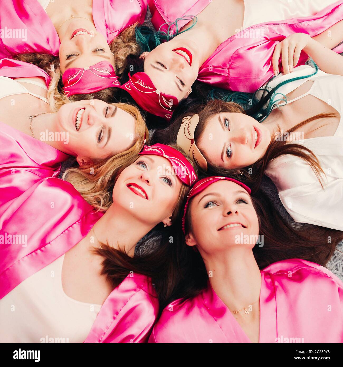 Portrait of beautiful girls in pink robes celebrating bridal shower. Stock Photo