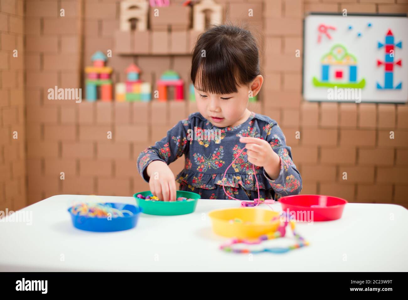 toddler girl string wooden bead crafts for homeschooling Stock Photo